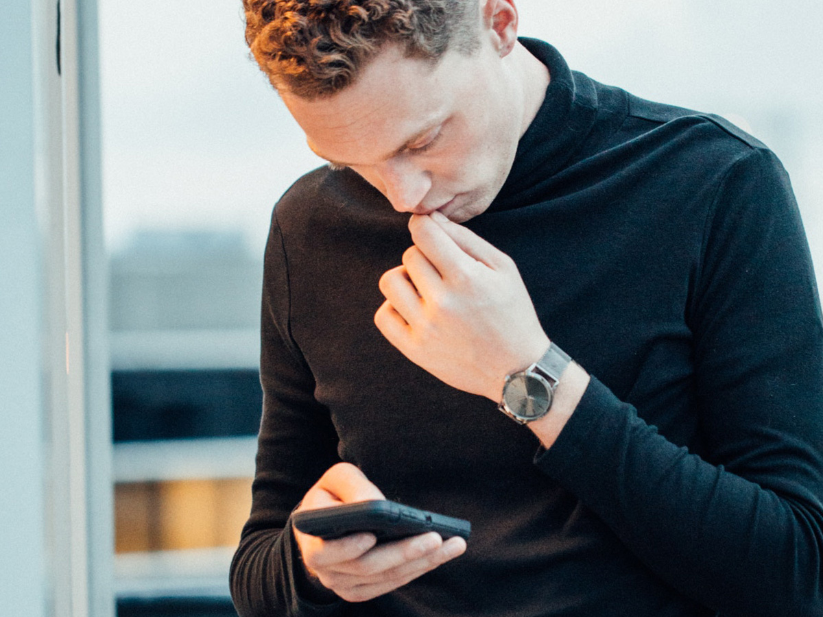 Man stareing intently at his smartphone Screen