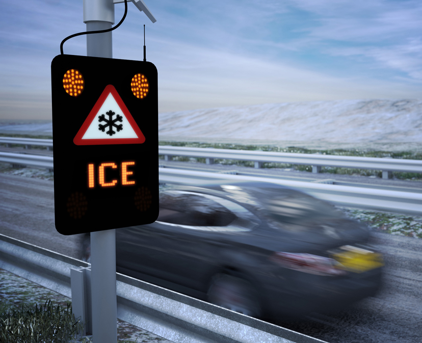 Realistic 3D Animation of a car driving very fast past an electronic ice warning sign on a motorway