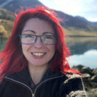 Animator standing in front of a mountain lake in Iceland